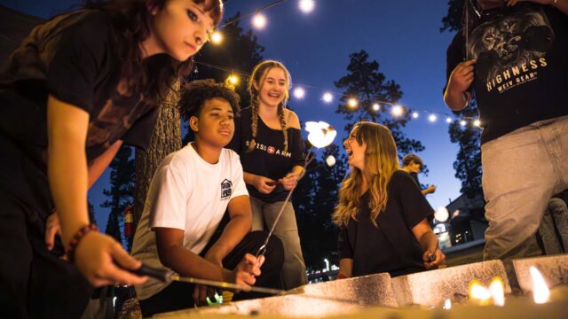 Campers enjoying s'mores at night