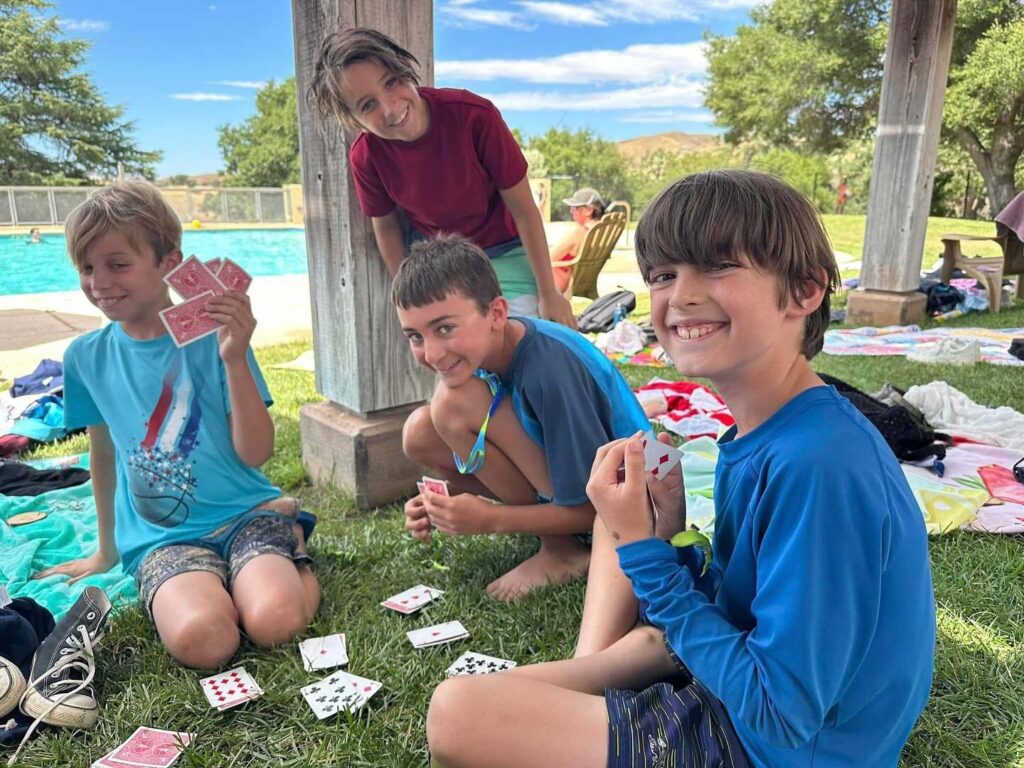 Boys playing cards by the pool