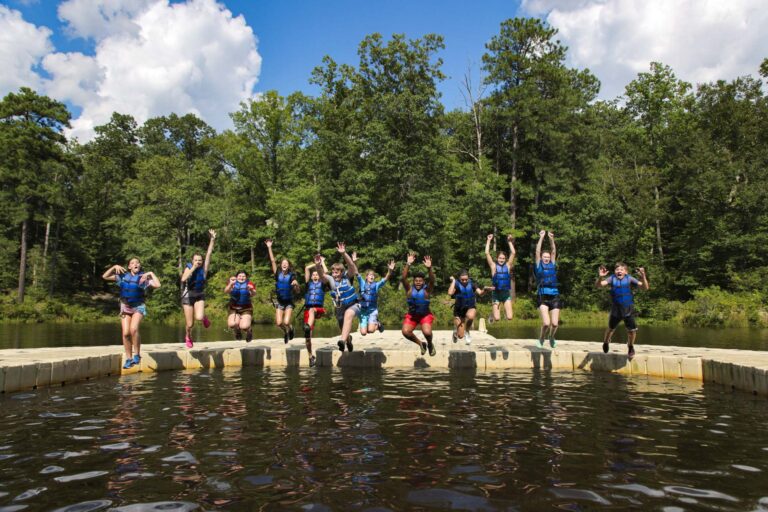Campers jumping into the lake