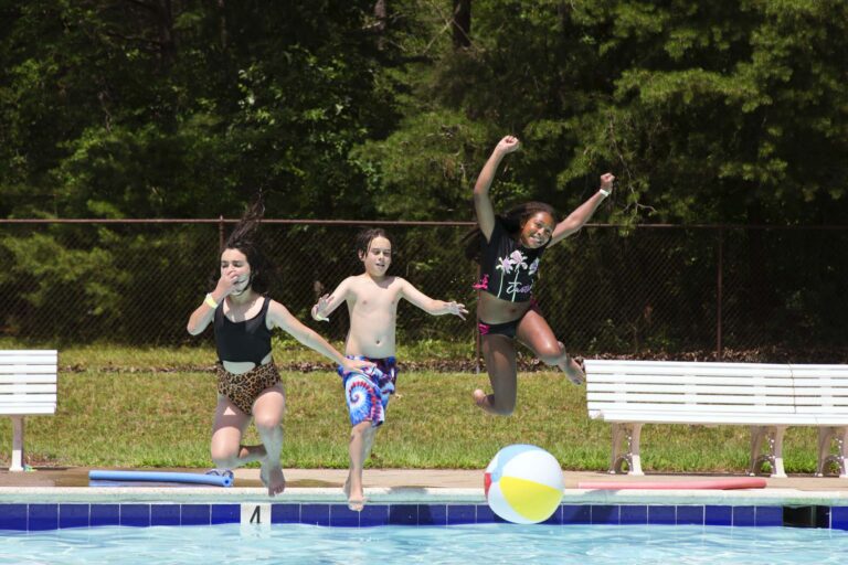 Campers jumping into the pool