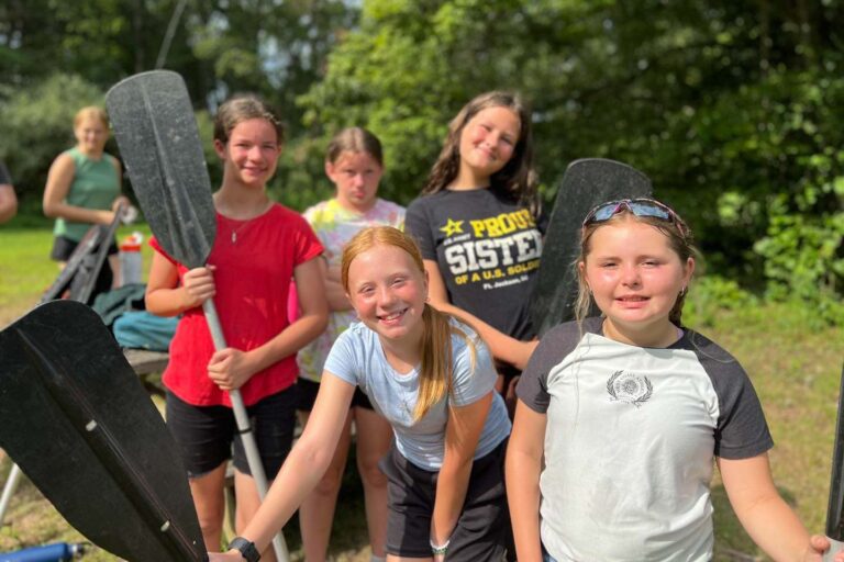Girls holding canoe paddles