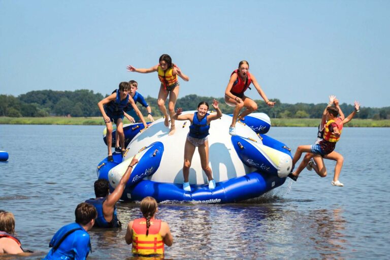 Campers jumping off water inflatable
