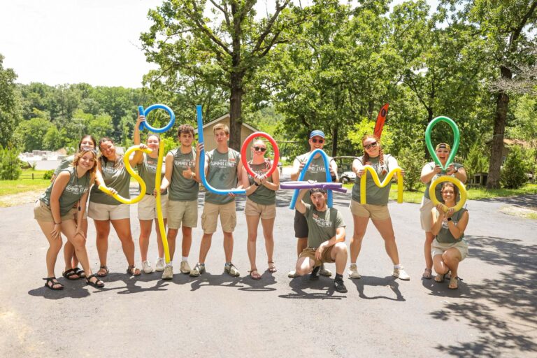 Staff using pool noodles to spell camp name