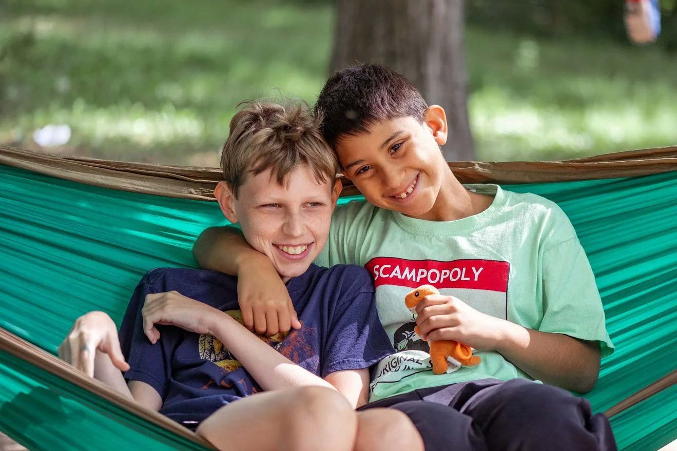 Happy boys sharing a hammock