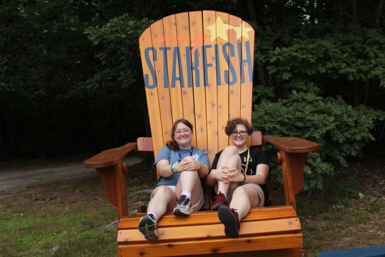 Campers in oversized Adirondack chair
