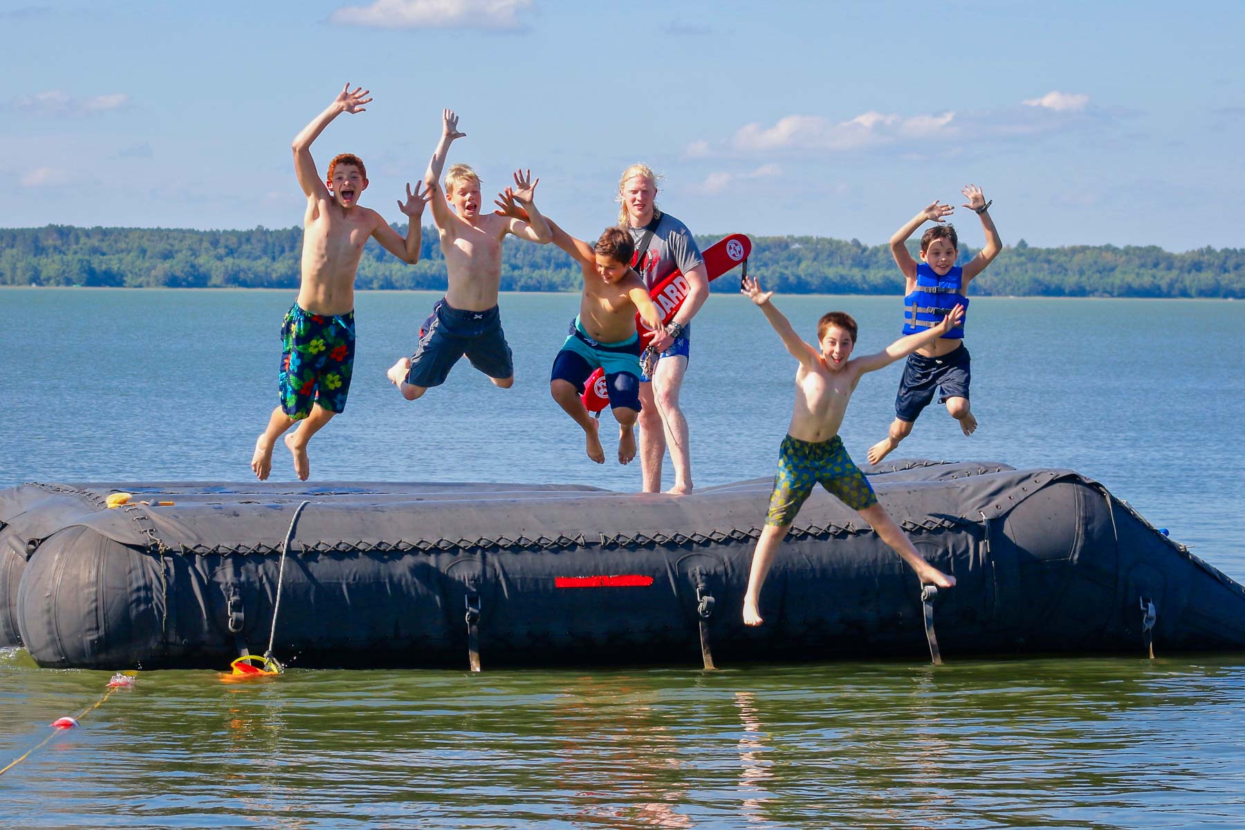 Boys jumping into a lake together