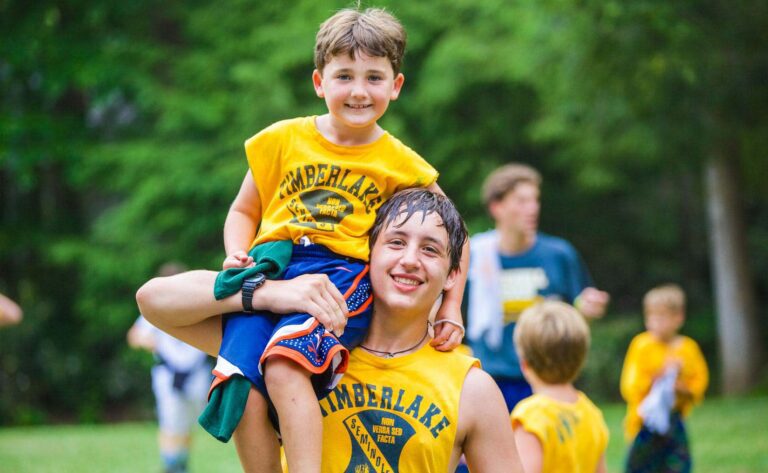Counselor holding up camper