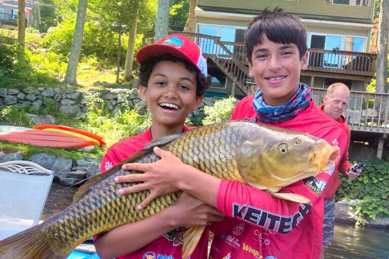 Two boys holding massive fish
