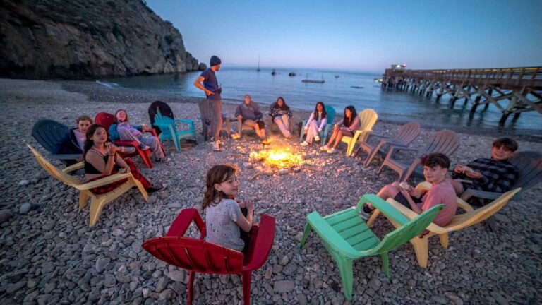 Campers enjoying a camp fire on the beach at dusk
