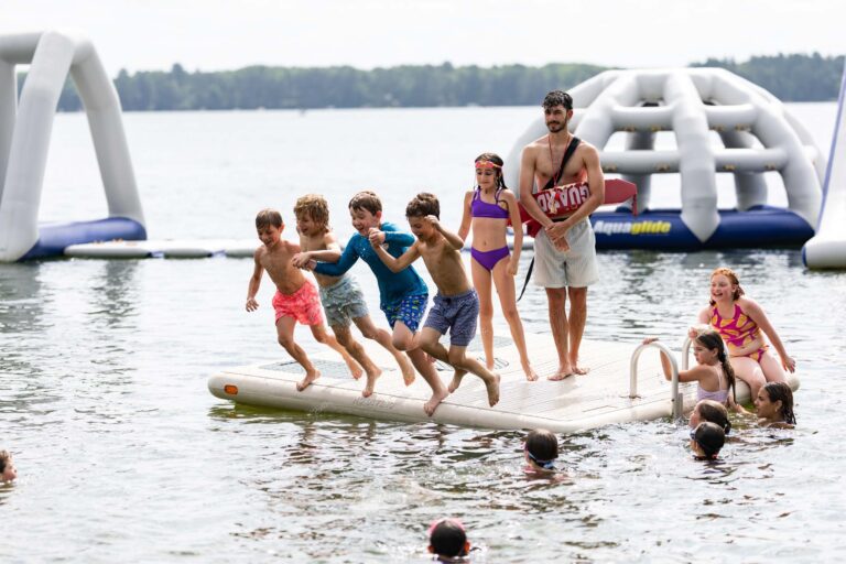 Boys jumping into lake together