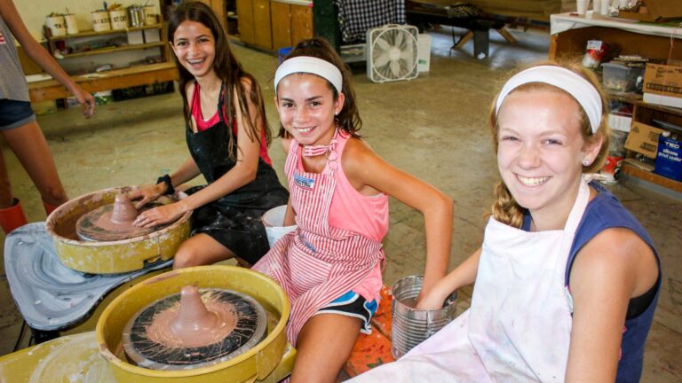 Girls using pottery wheels