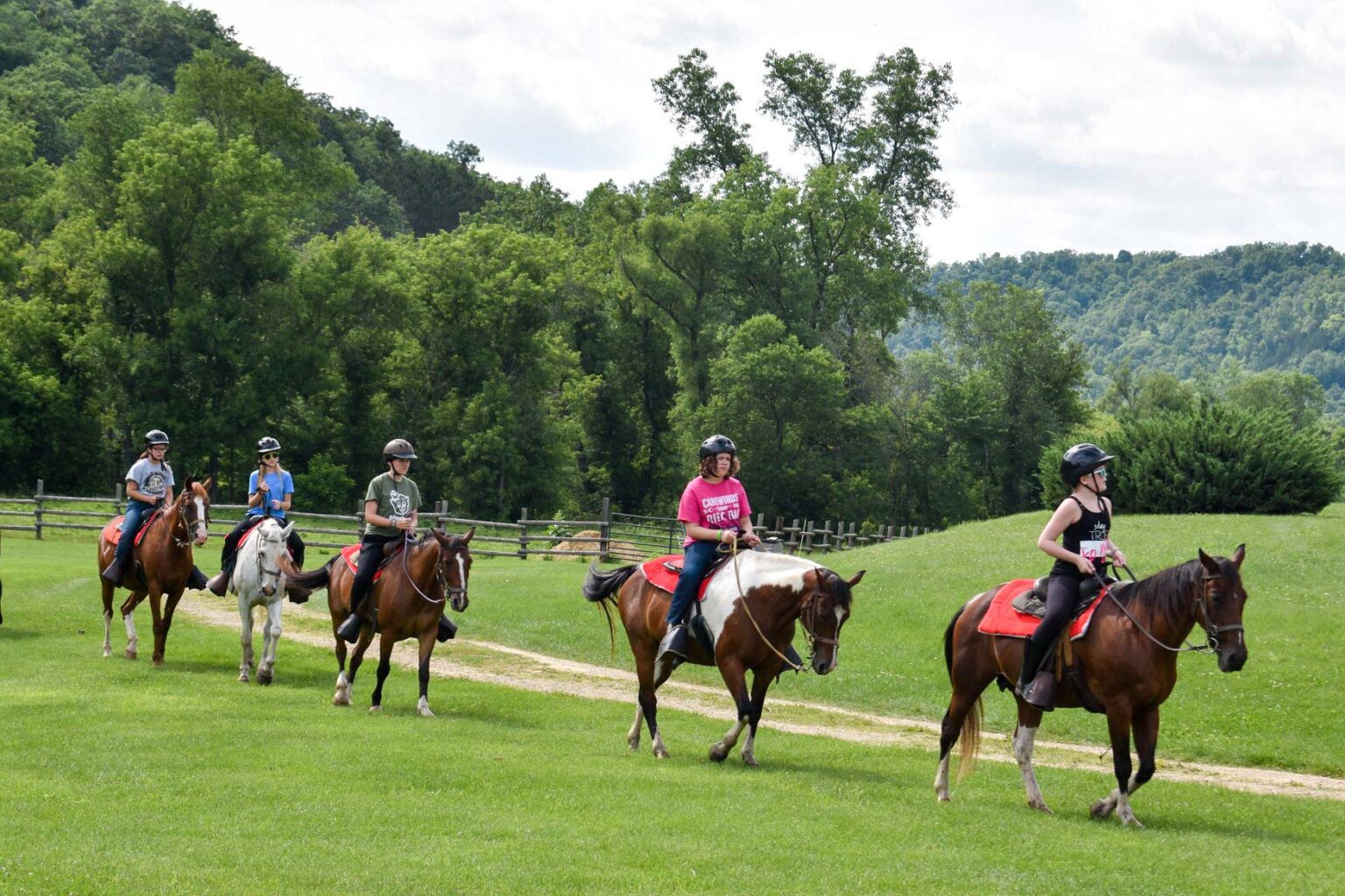 Campers riding horses on a trail
