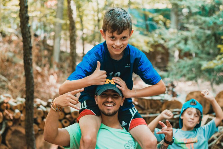 Boy sitting on his counselors shoulders