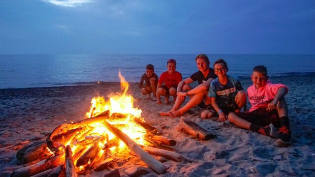 Boys around a shoreline camp fire