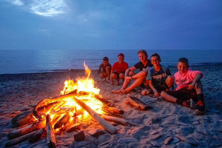 Boys around a shoreline camp fire