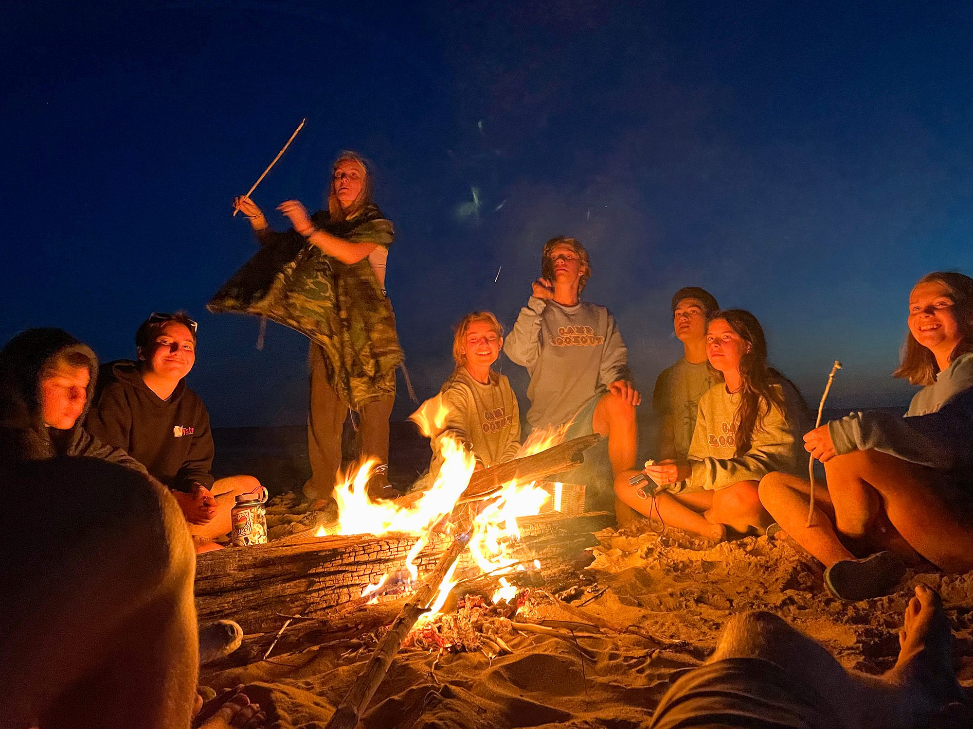 Kids around a beach campfire