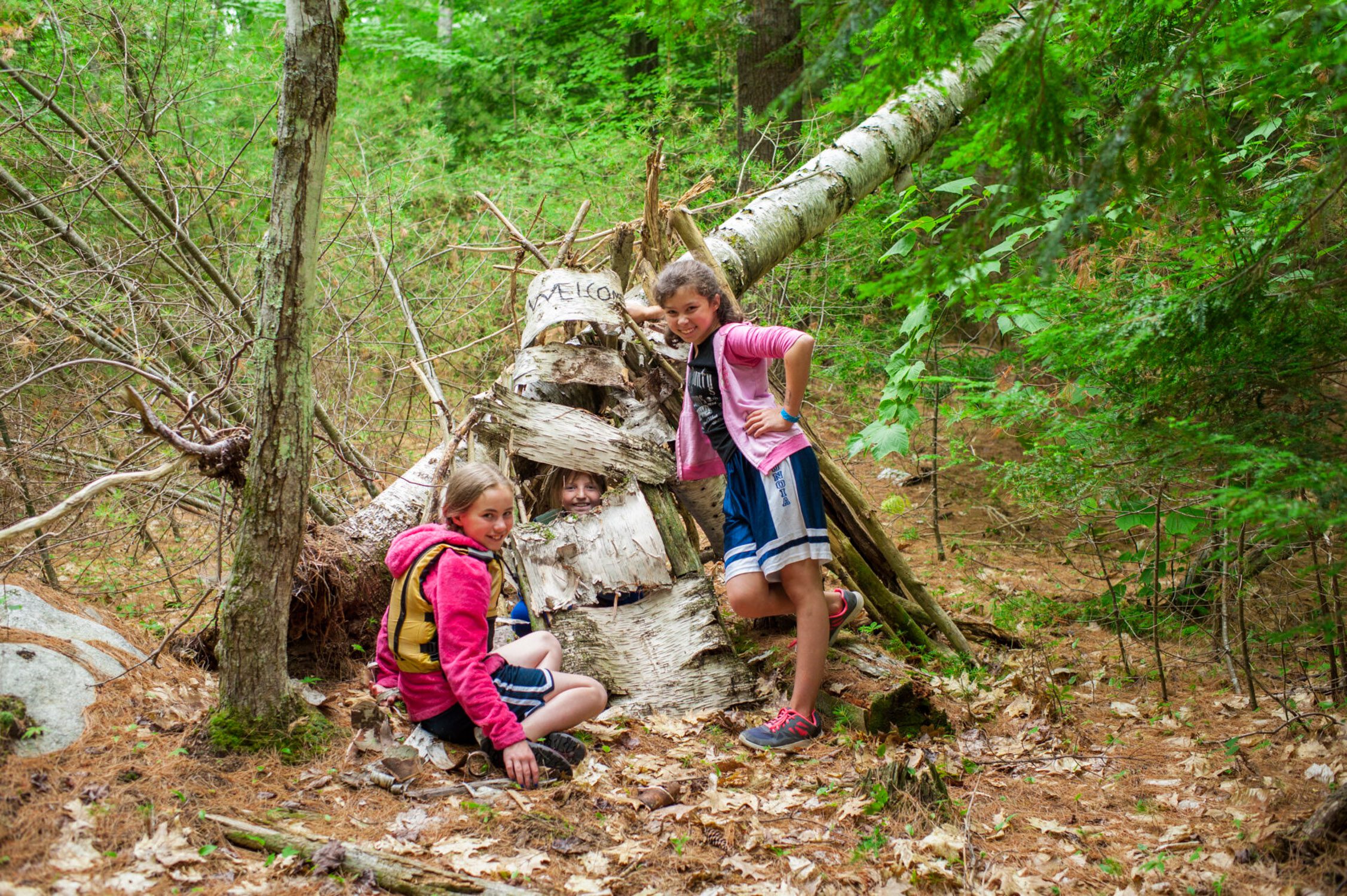 Girls near bushcraft shelter