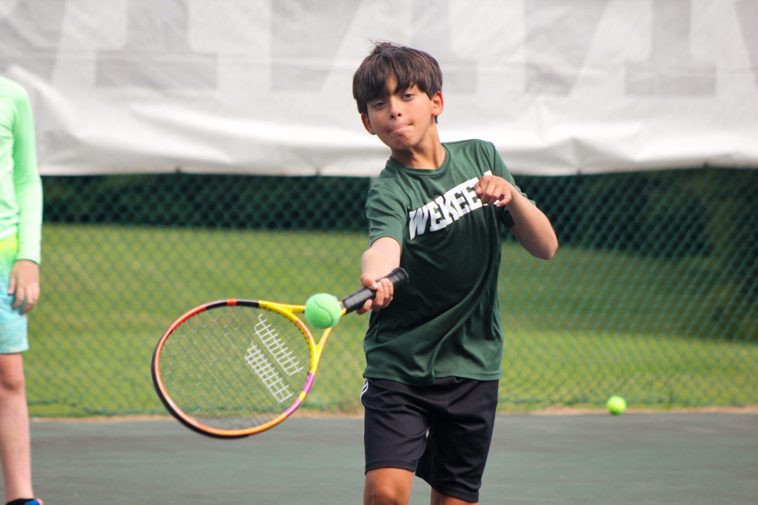 Boy hitting tennis ball