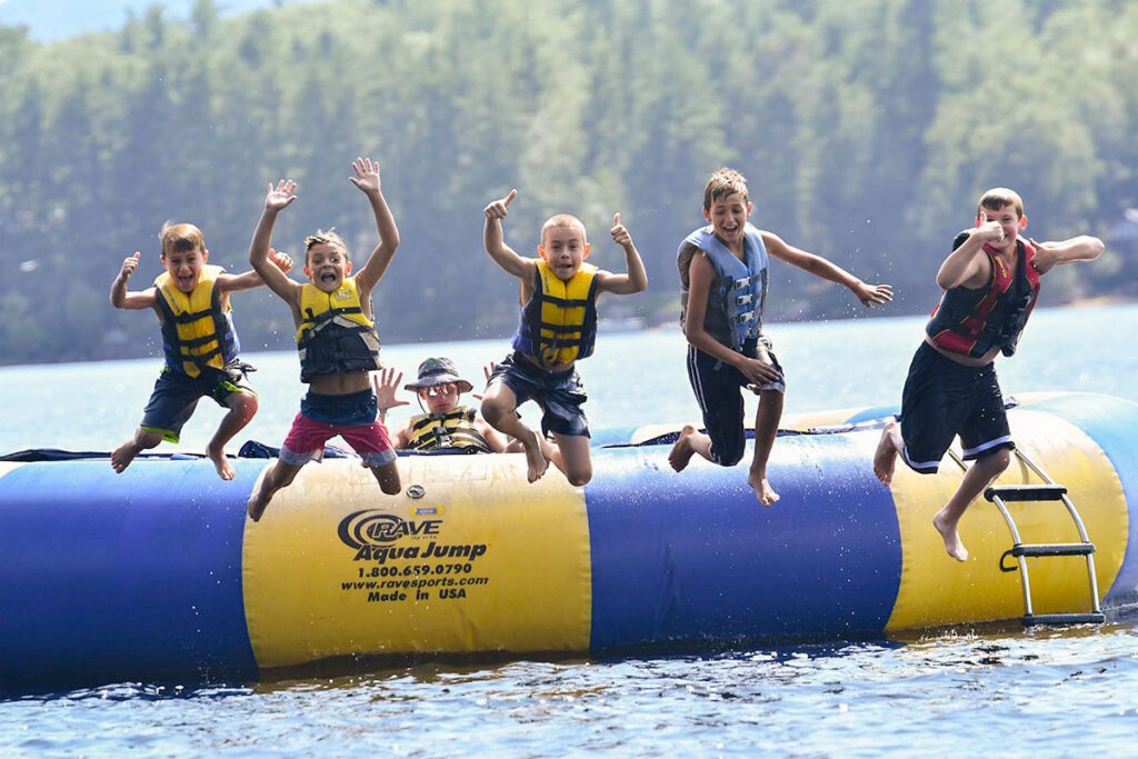 Boys jumping off water trampoline
