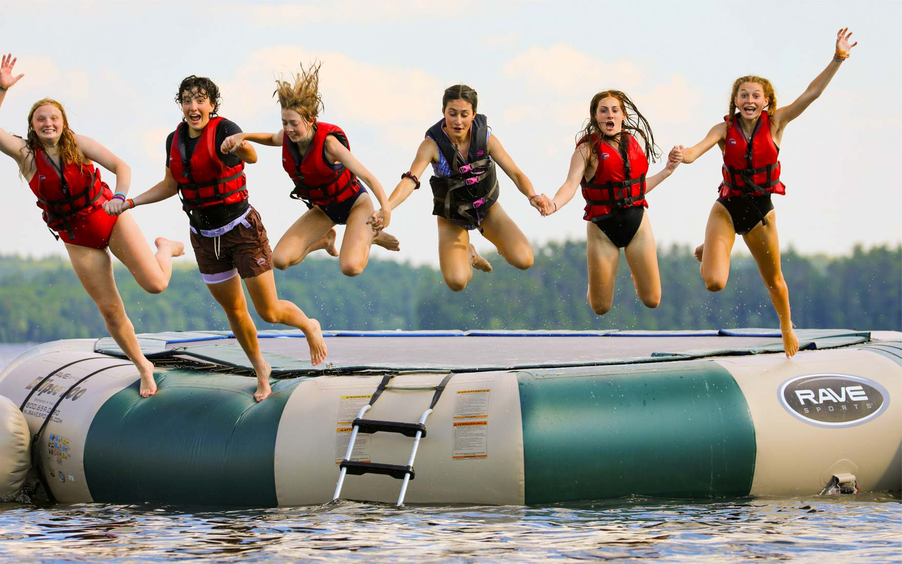 Girls jumping into lake together