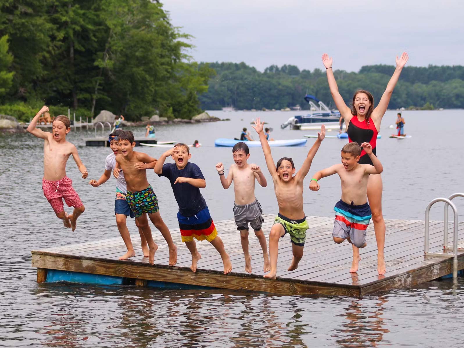 Boys jumping into lake together