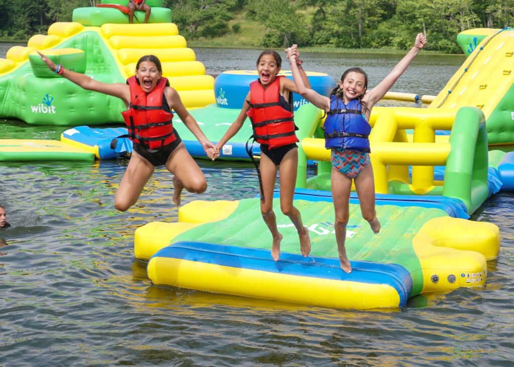 Three girls jumping into a lake together