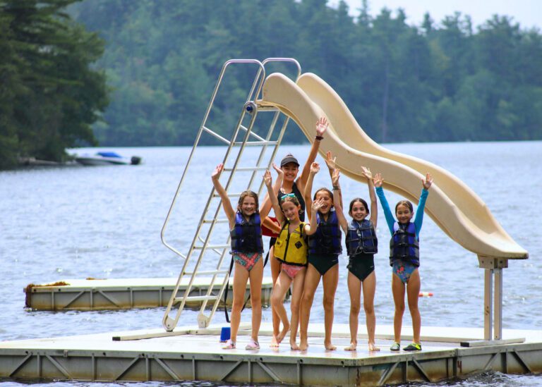 Girls on floating water slide platform