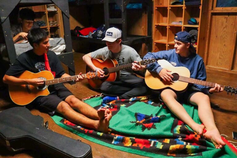 Campers playing guitar in their cabin