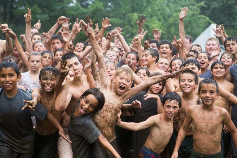 Cheering boys covered in mud
