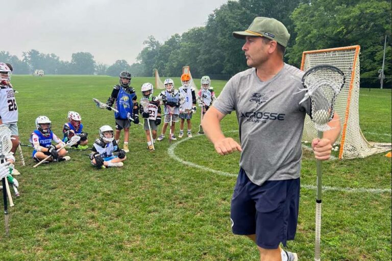 Instructor teaching lacrosse skills