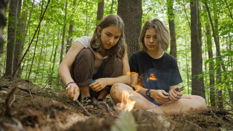 Teen campers tending a camp fire