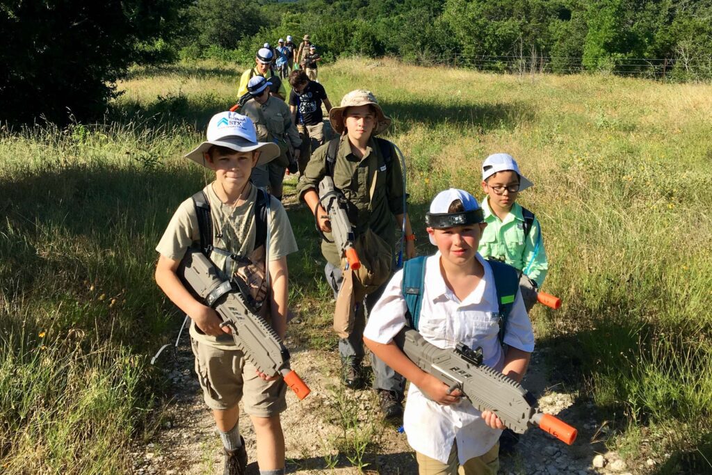 Boys trekking with laser tag rifles