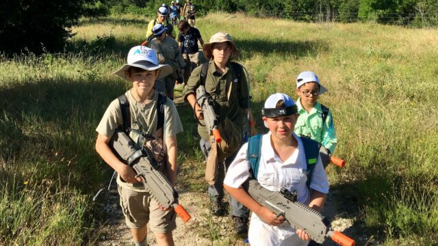 Boys trekking with laser tag rifles