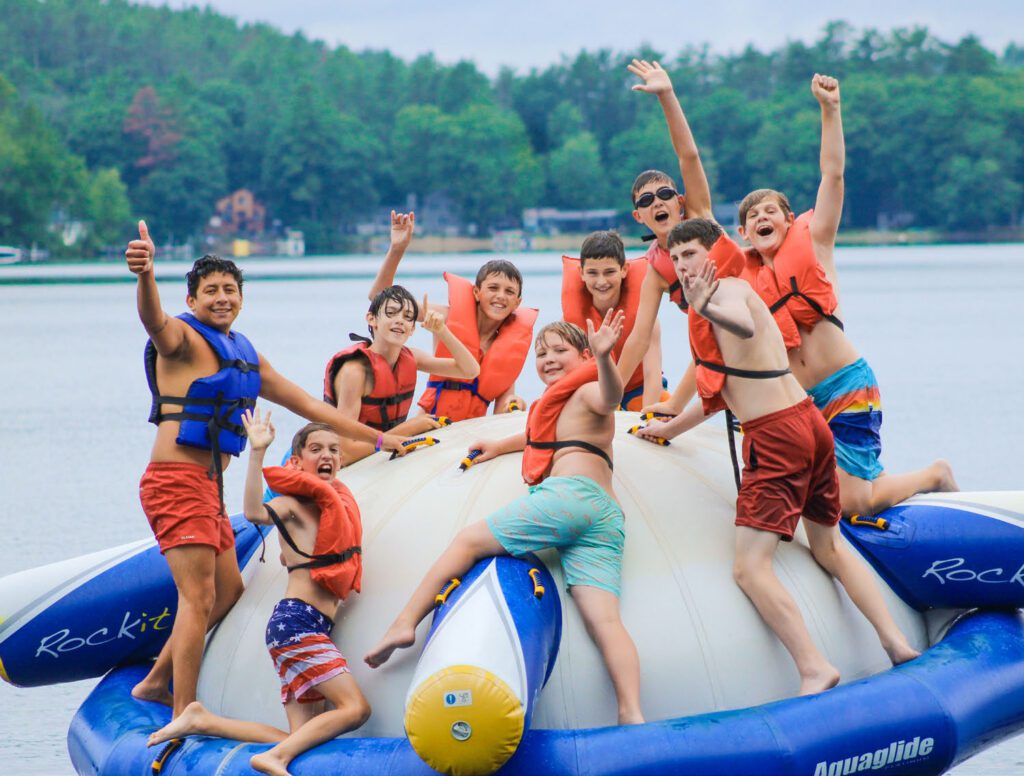 Cheerful boys playing on giant water inflatable