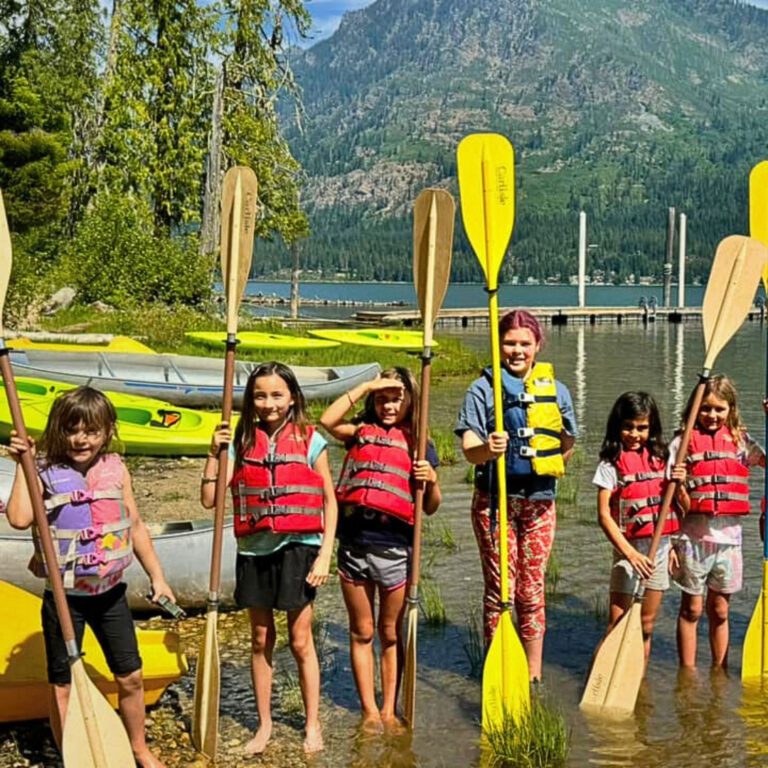 Girls in lake holding oars