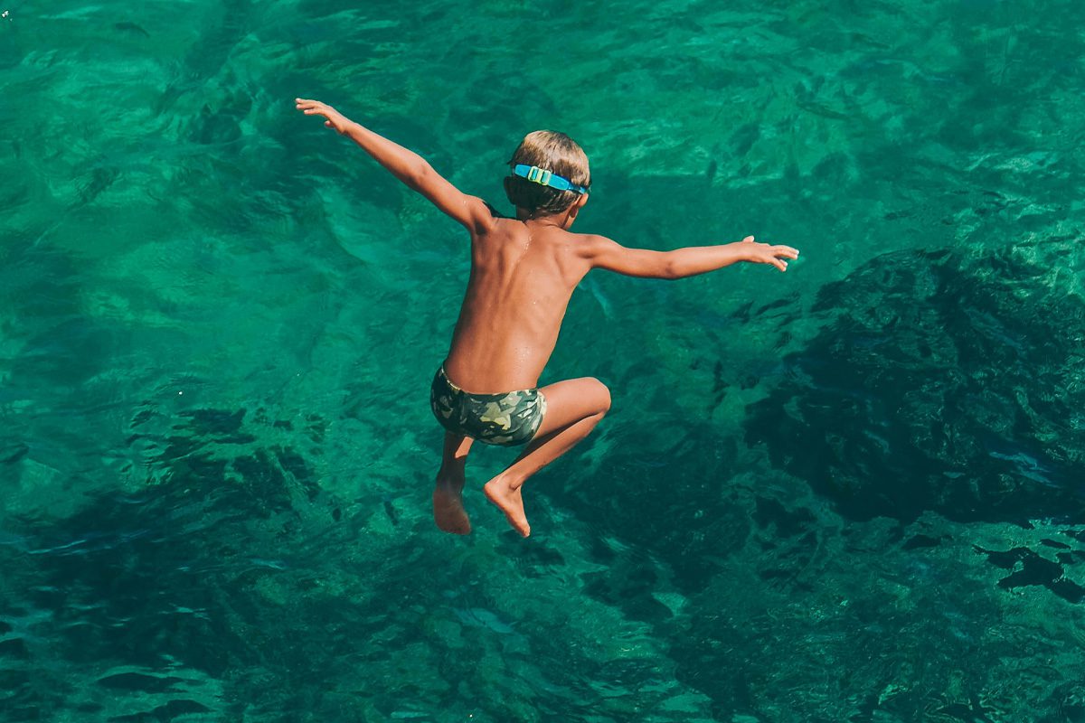 Boy jumping into water