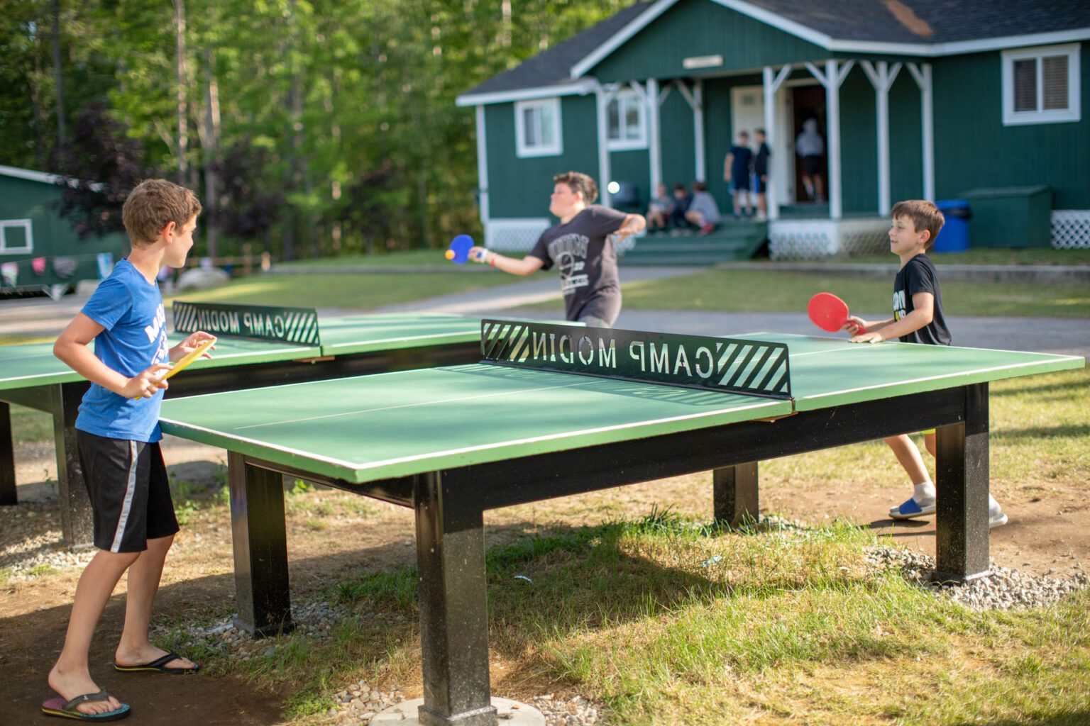 Boys playing table tennis outdoors