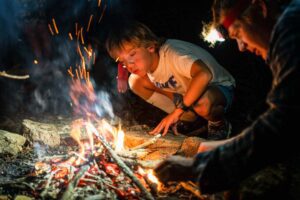 Boy building a fire at night