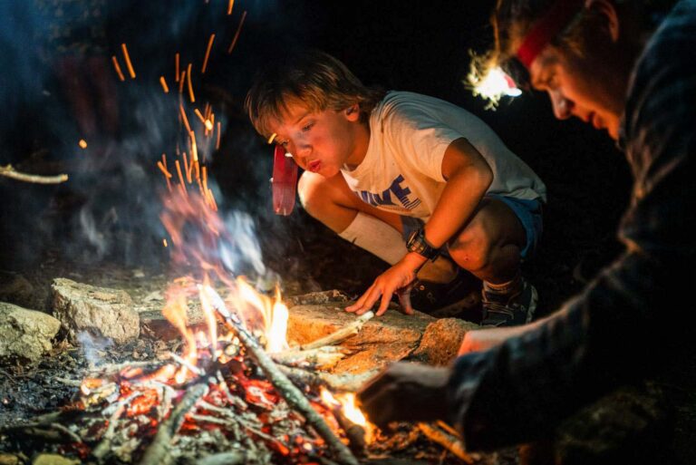 Boy building a fire at night