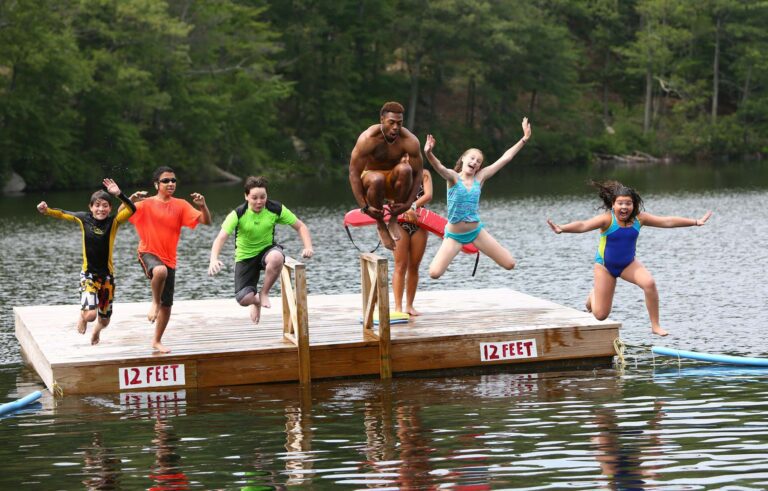 Campers jumping into the lake