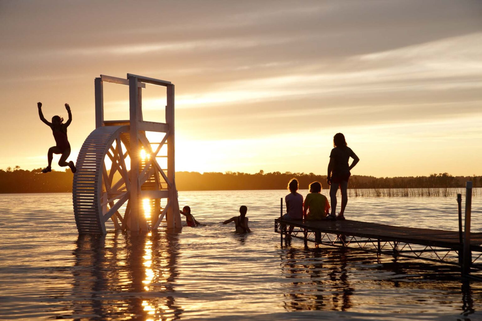 Girls playing in lake at sunset