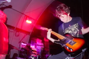 Teen boy playing guitar on stage