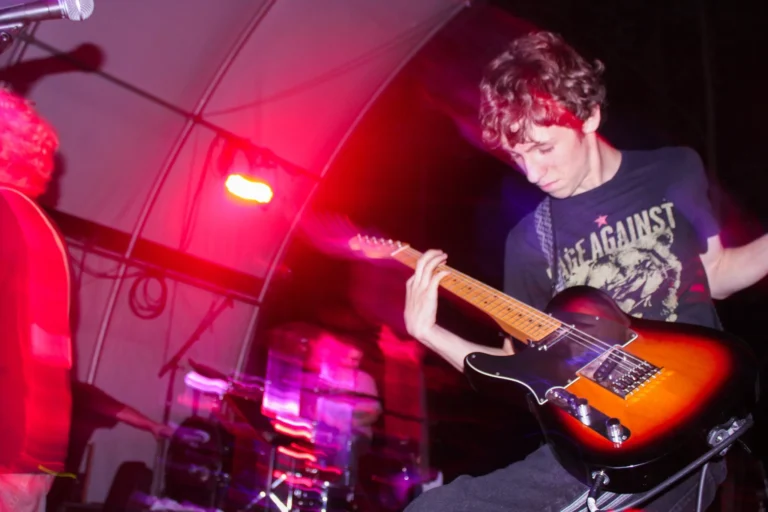 Teen boy playing guitar on stage