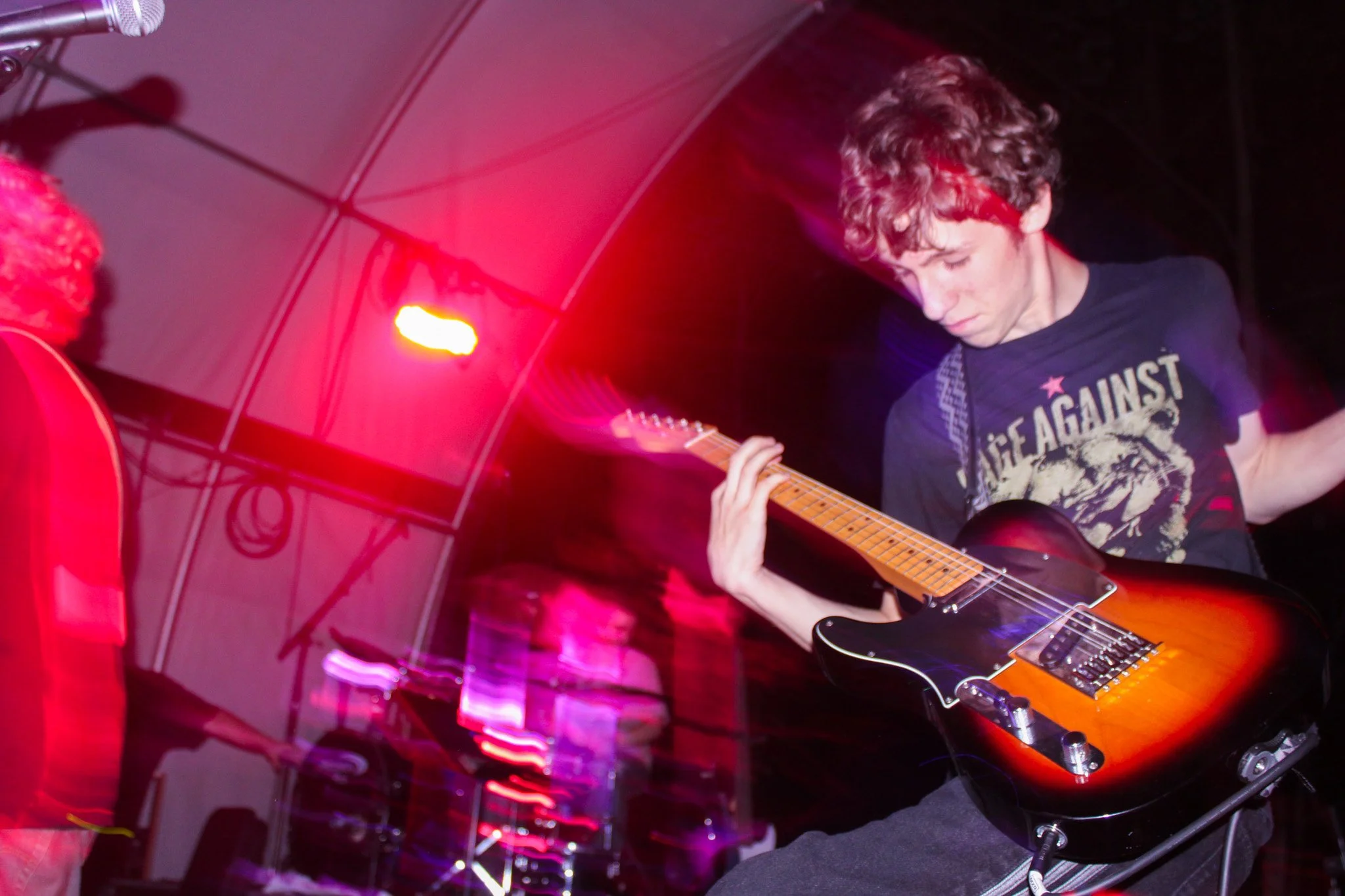 Teen boy playing guitar on stage