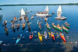 Armada of boys in canoes, kayaks, and sail boats