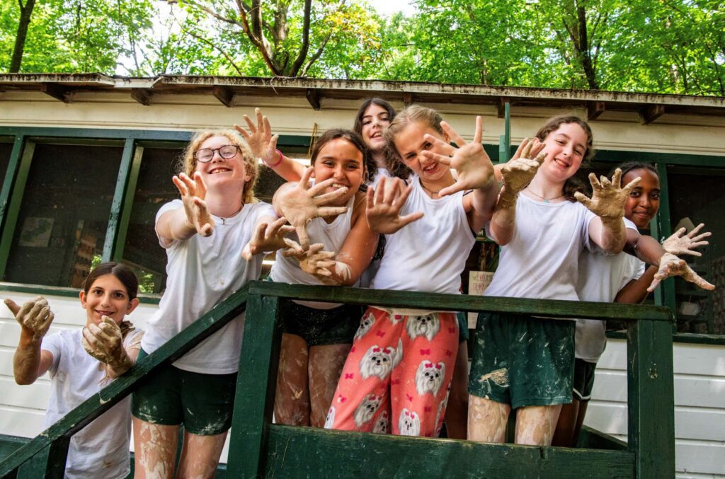 Girls with clay-covered hands