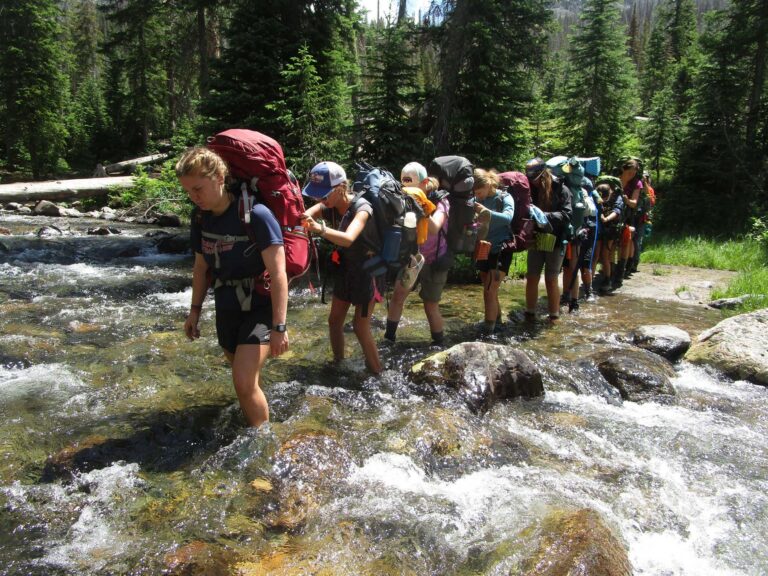Teen hikers crossing a creek