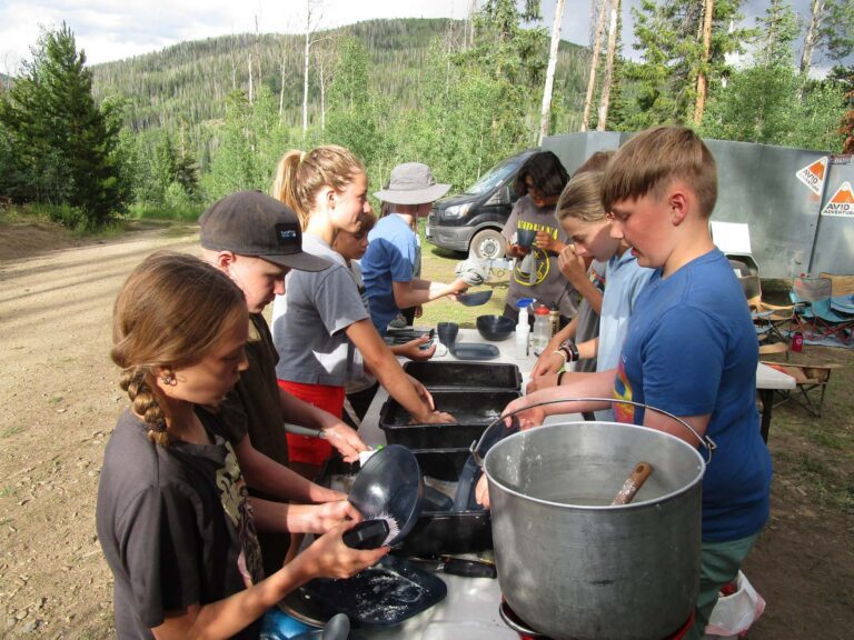 Backpacking campers cleaning their dishes in nature